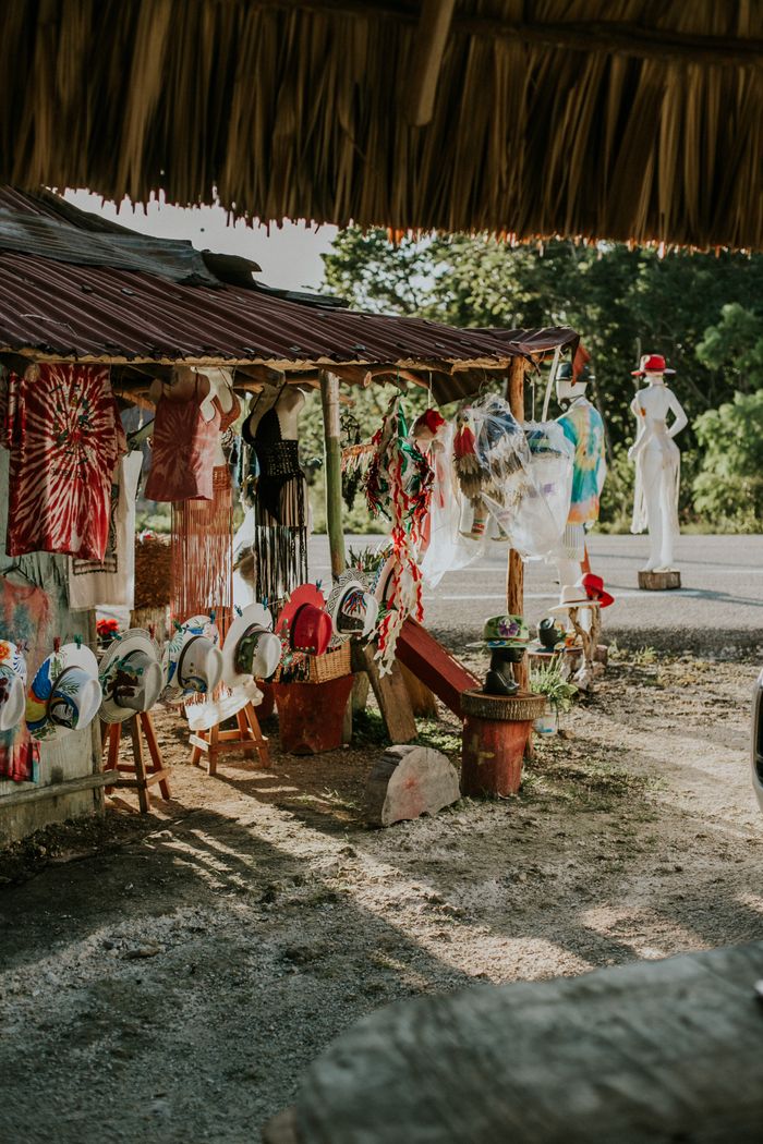 Outdoor market with vibrant handmade crafts under rustic canopy in warm sunlight.