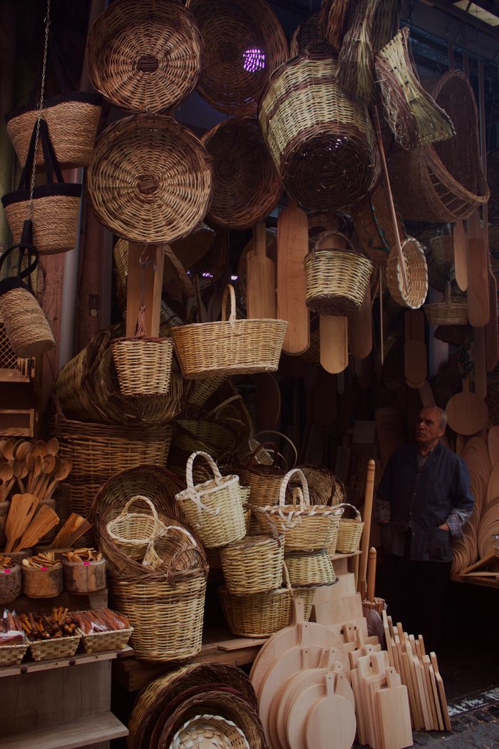 A charming display of hanging woven baskets and wooden items at an outdoor market stall.